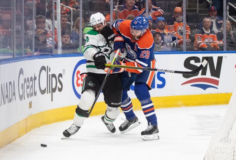 Two hockey players battle for the puck. 