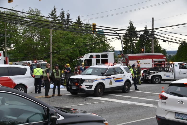 Police, firefighters, and paramedics can be seen attending the collision scene Monday afternoon. 