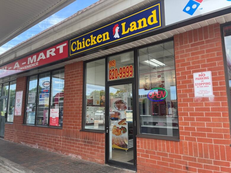 The Chicken Land restaurant is scene with an open sign.