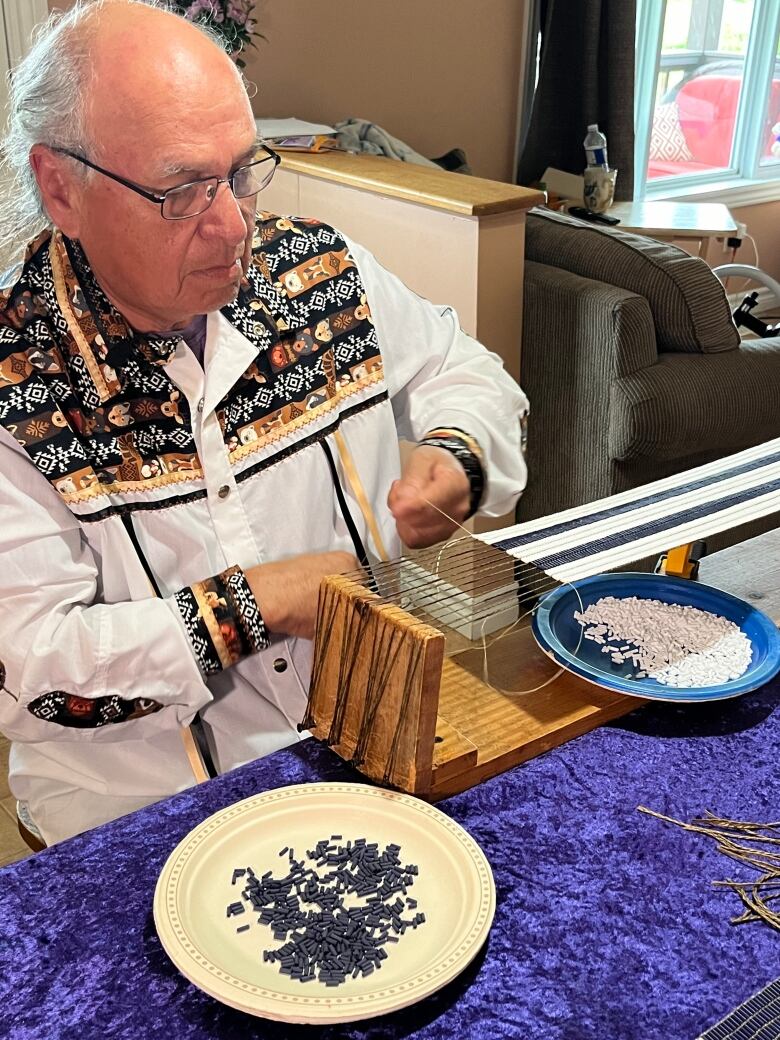 Man making two row at beading loom.