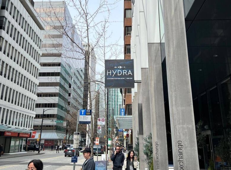 A photo of a street in Vancouver with a restaurant sign that says 