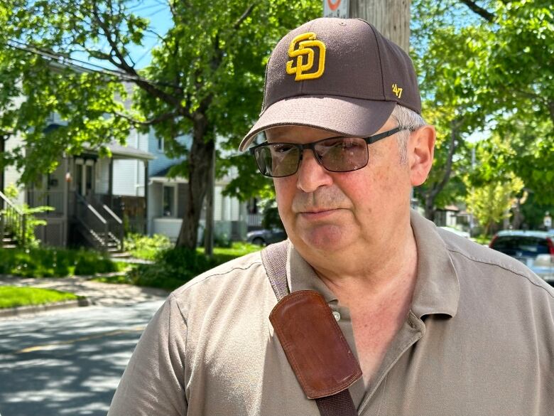 A man in a ball cap looks at the camera. 