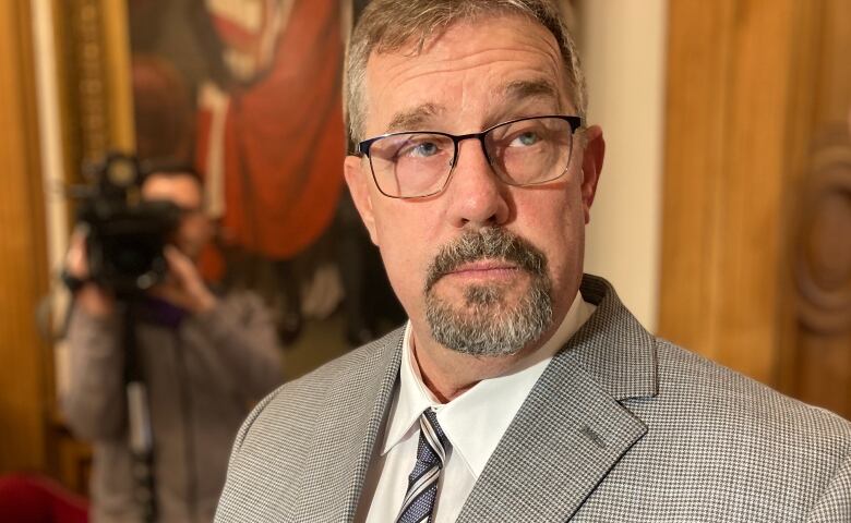 A closeup of a man with glasses and a goatee.