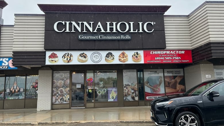 Exterior shot, in rain, of a business called Cinnaholic