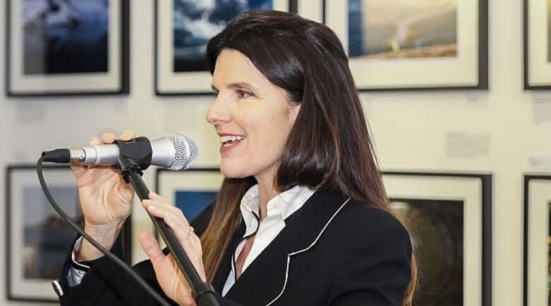 A woman speaks into a microphone