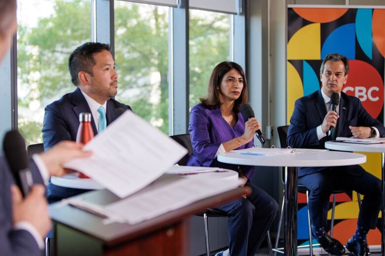 Mississauga mayoral candidates Dipika Damerla, centre, Stephen Dasko, right, and Alvin Tedjo, left, take part in a live debate hosted by the CBCs David Common, at the Living Arts Centre, on May 30, 2024.