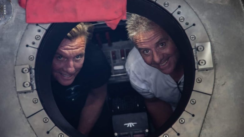 Two men inside a submersible window.