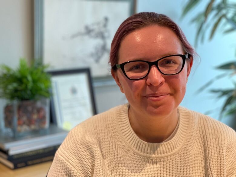 A woman wearing glasses poses for a photo.