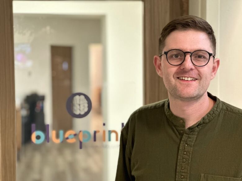 Jared Dalton, CEO of Blueprint Counselling standing at his business and smiling.