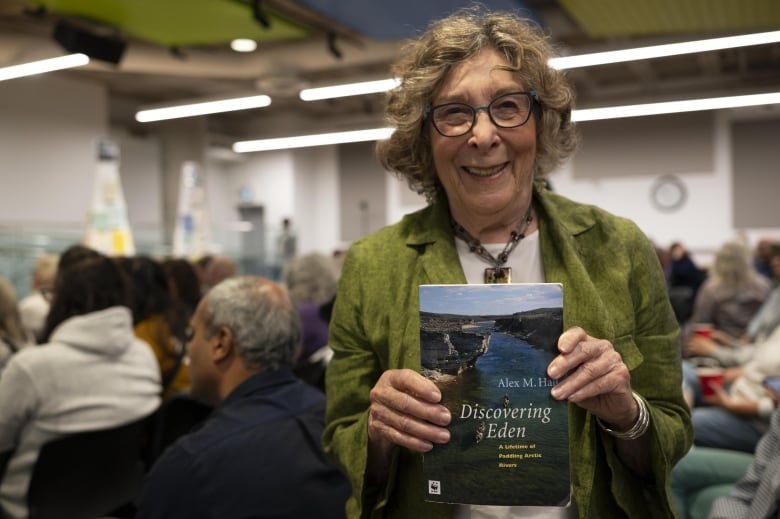 Susan Barreca holds a copy of Alex Hall's Discovering Eden.