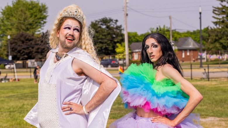 Two drag performers stand. 