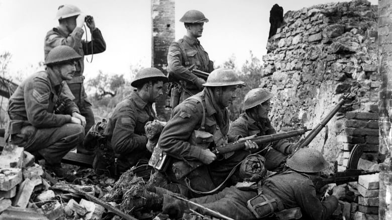 Seven Canadian soldiers are shown in a black and white photo from the Second World War in Italy.