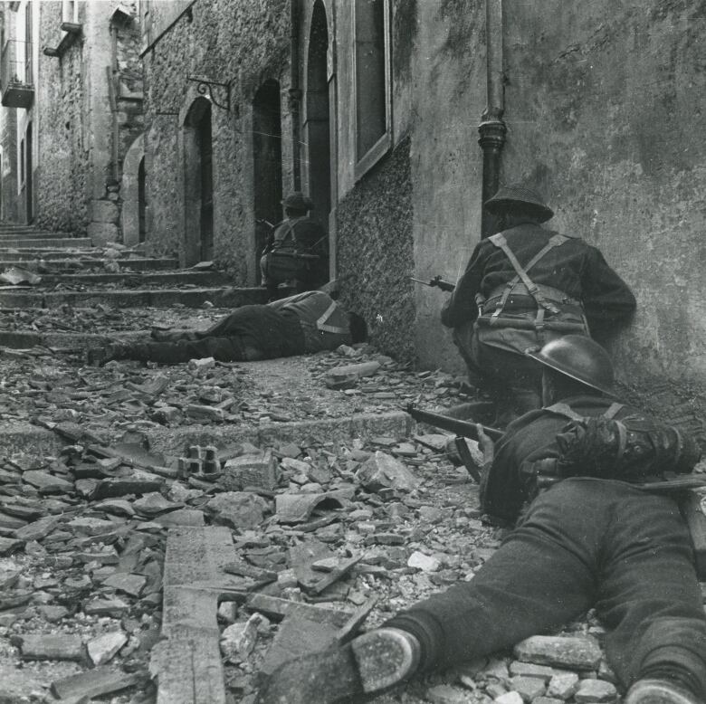 Four Canadian soldiers hunt for snipers in Campochiaro, Italy, in an undated, black and white photo from the Second World War.