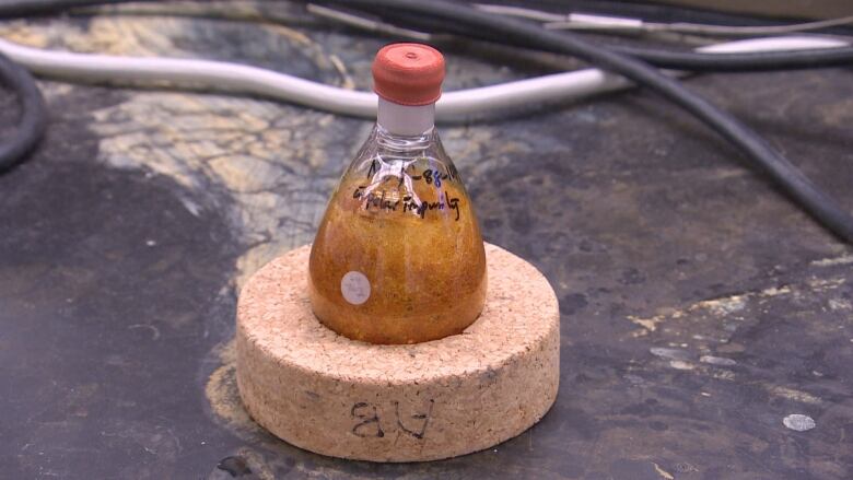 Abscisic acid is shown in a glass flask in a laboratory.