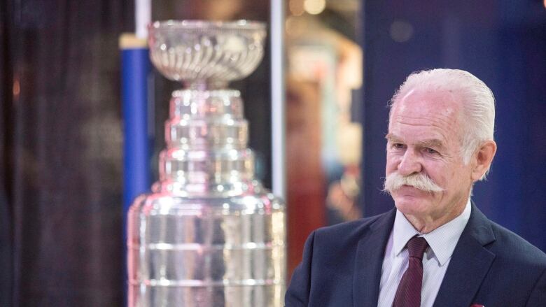 A man is pictured next to a silver trophy.