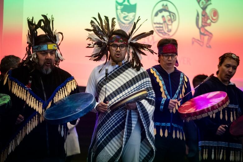 Four people are drumming