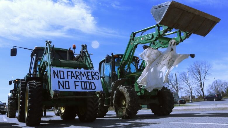 two tractors have banners saying 