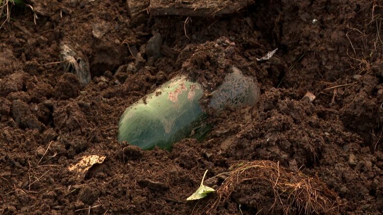 A glass bottle buried in soil 