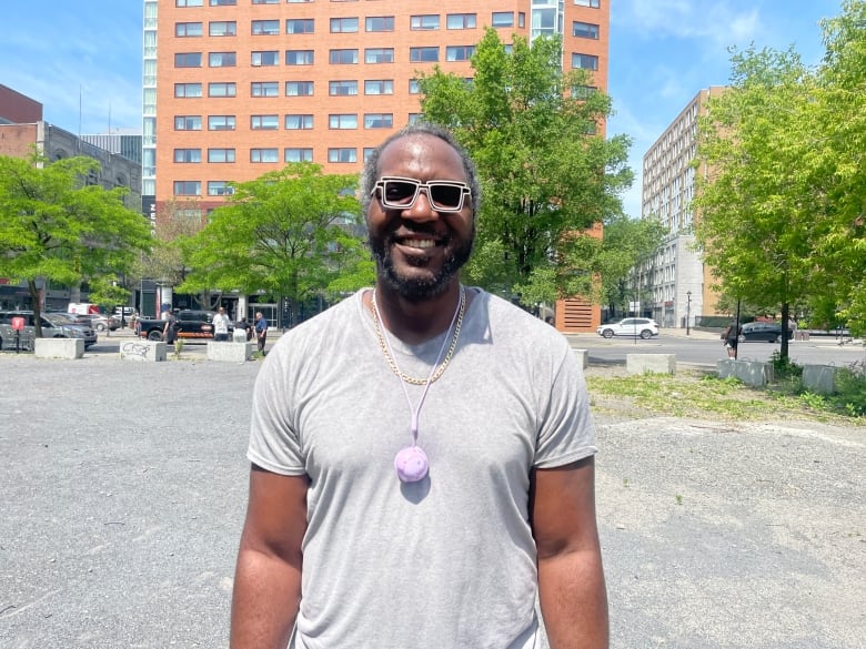 A man in a grey shirt smiling. 