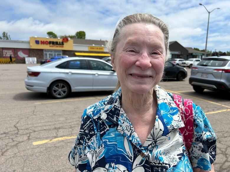 Woman standing in No Frills parking lot.