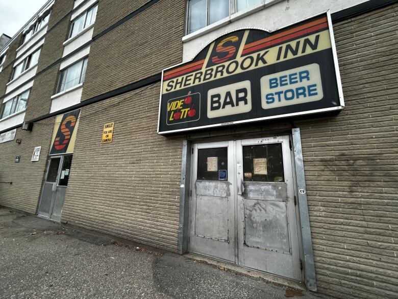 A Sherbrook Inn sign hangs above a metal doorway. 