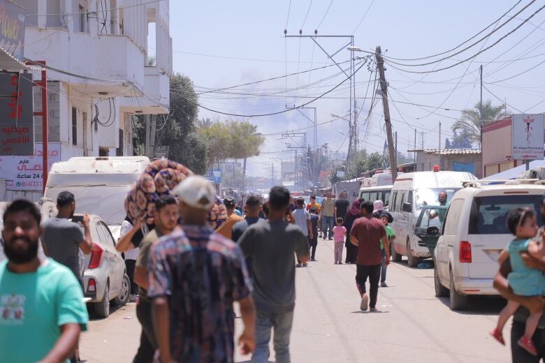 Smoke from an Israeli strike in Central Gaza rises in the background of Deir El Balah,  as people continue to flee from attacks.