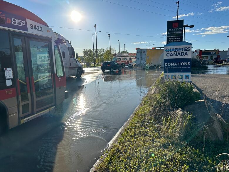 a bus drives through a big puddle 