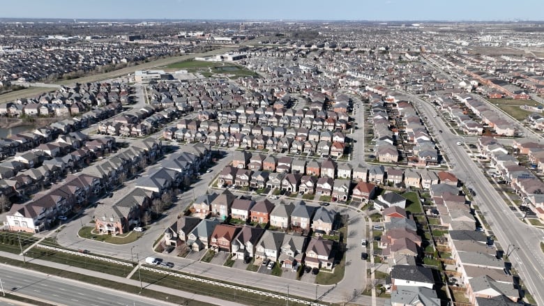 a large suburban sprawl shows many houses and roads.