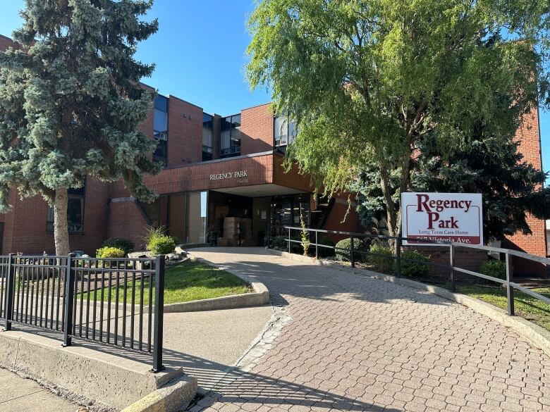 A building with a sign out front that reads Regency Park Long-Term Care Home.