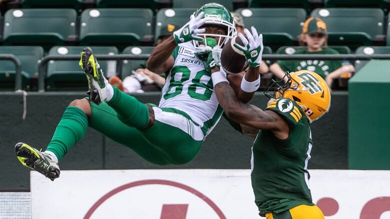 Saskatchewan Roughriders' Dohnte Meyers  makes the catch as Edmonton Elks' Kai Gray  tries to block the pass during first half CFL pre-season action in Edmonton, Alta., on Saturday May 25, 2024. 