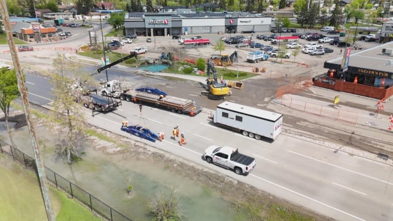 a large parking lot and a closed off road. there is construction equipment.