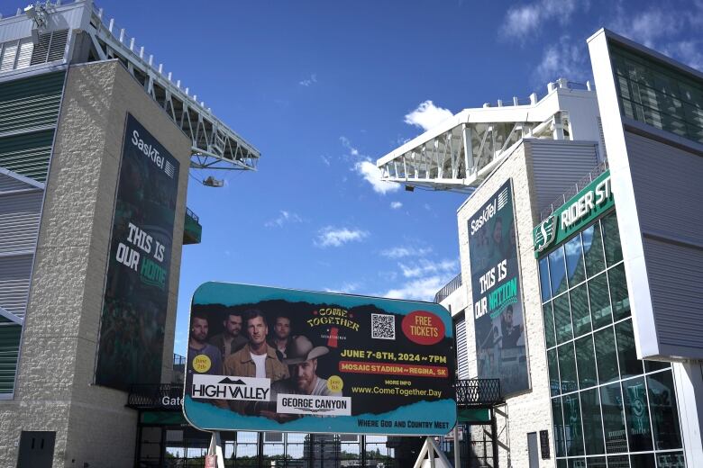 A billboard sits outside Mosaic Stadium in Regina. The billboard advertises Country music artists at a Come Together Event on June 7 and June 8. 