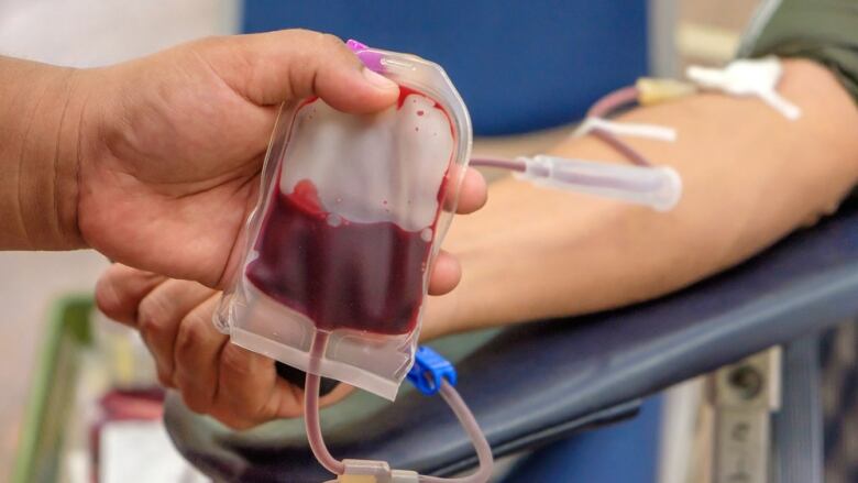 A person in a medical setting is receiving a blood transfusion. 