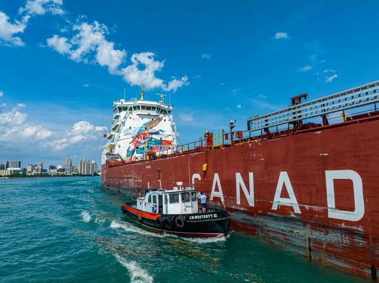 Small boat attached to the side of a larger vessel marked Canada