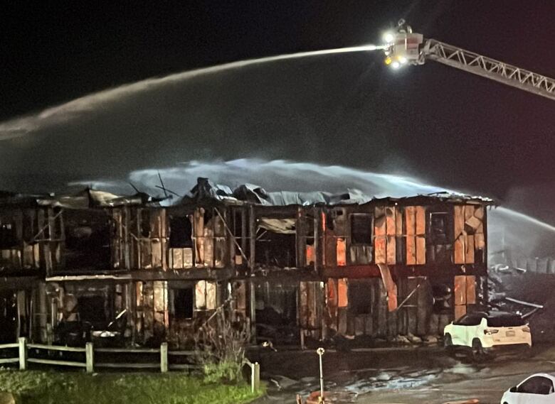 Firefighters battling a fire in an apartment building at night.