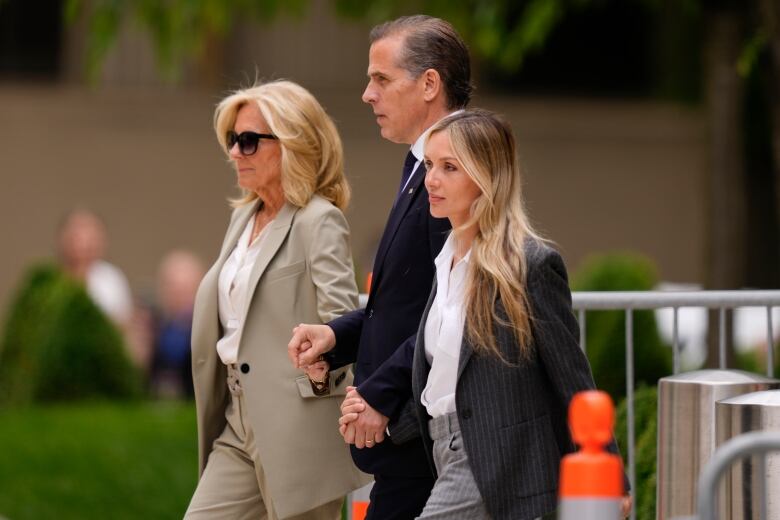 Hunter Biden, centre, walks with his mother on the left and his wife on the right.