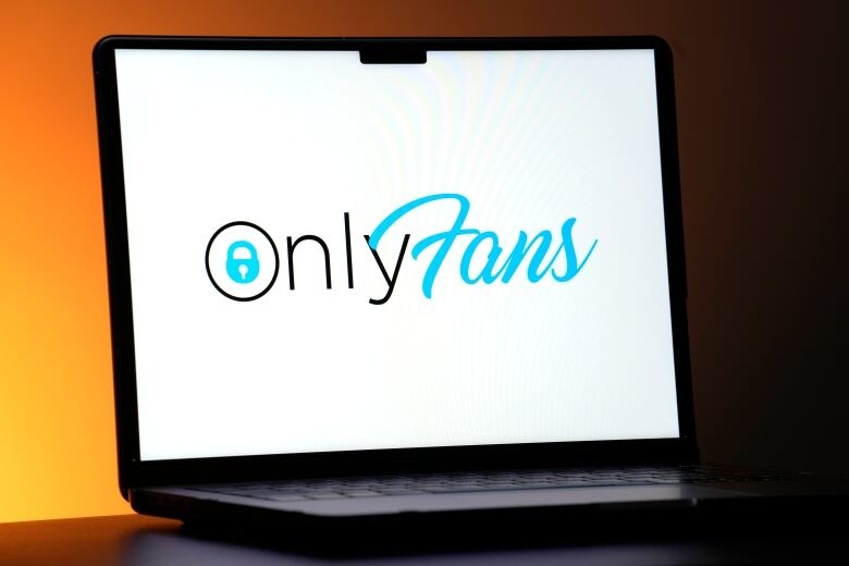 A laptop with a logo, whose text reads 'OnlyFans'. The O in the logo has a blue lock inside it.