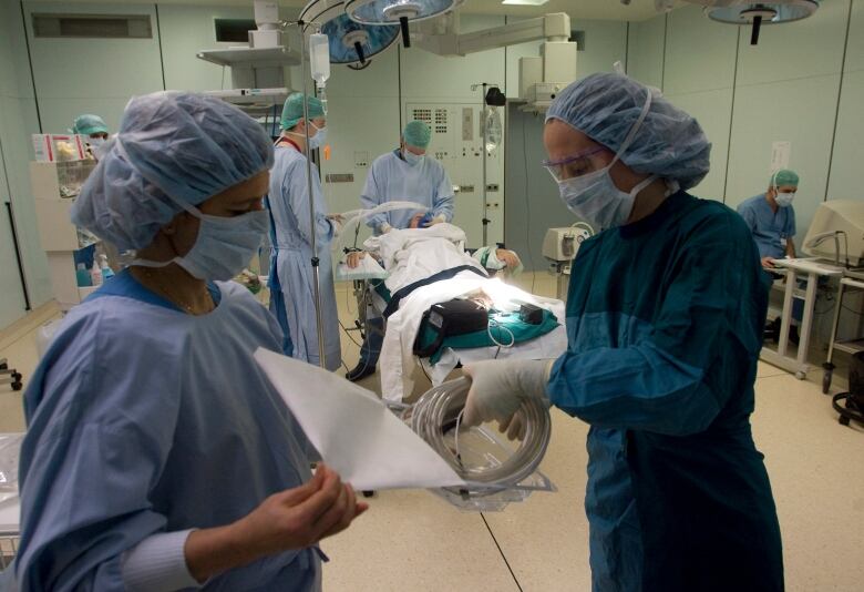 Theatre nurses make last preparations before starting procedures to clean the wound of an amputee patient with MRSA (Methicillin resistant Staphylococcus Aureus) in the operating theatre at the Unfallkrankenhaus Berlin (UKB) hospital in Berlin in 2008.