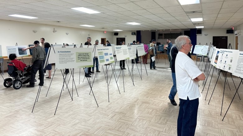 community members look at poster boards in a room 