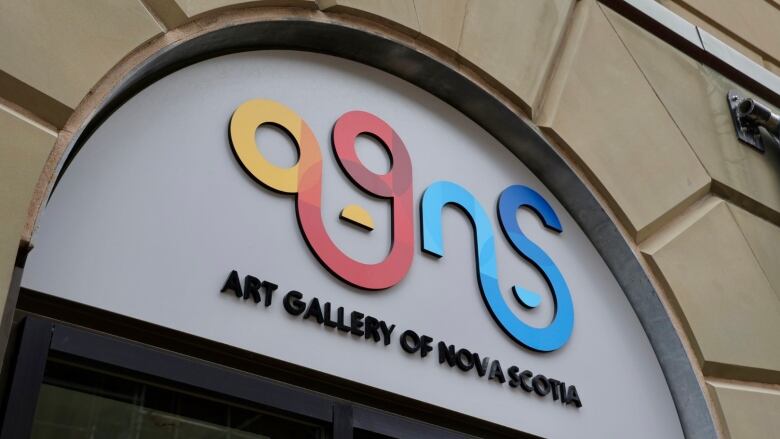 a modern sign on a historic brick building says AGNS: Art gallery of Nova Scotia 