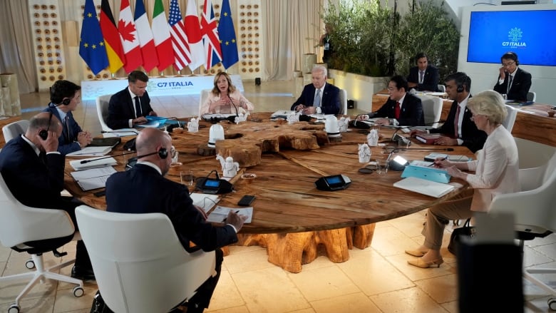 A group of world leaders sit around a table.