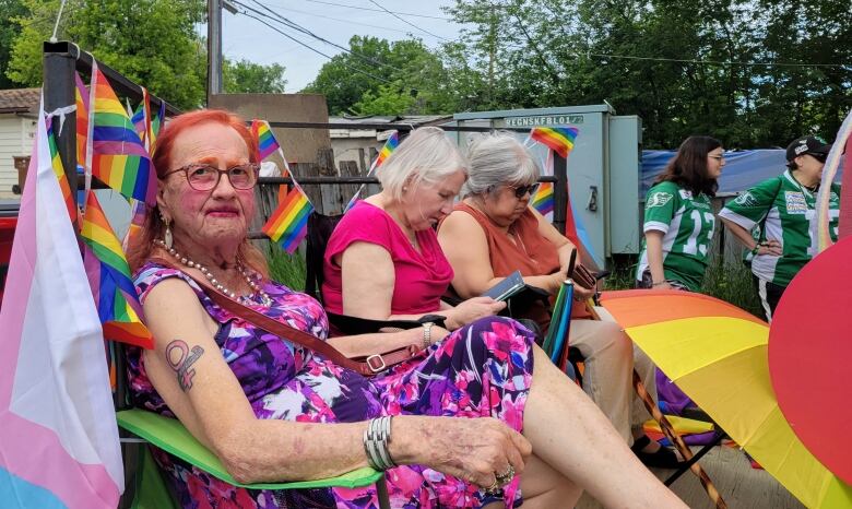 Person sitting with Pride flags behind her. 