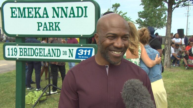 a man standing in front of a sign that says 'Emeka Nnadi Park.'