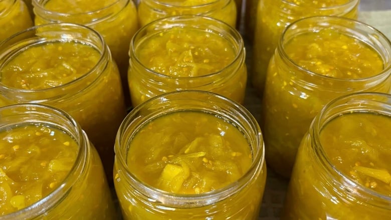 Several open jars of green tomato chow.