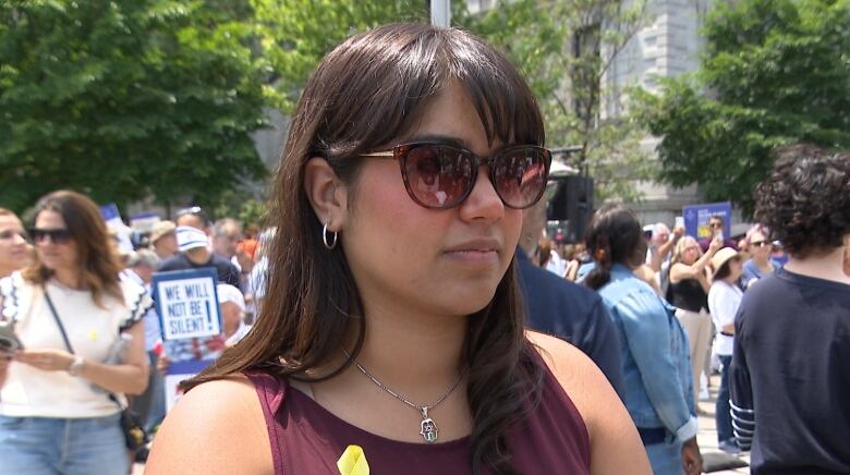 a woman wearing sunglasses and a burgundy top