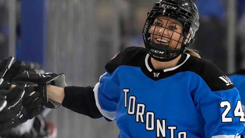 A Professional Women's Hockey League player from Toronto, wearing a blue, black and white jersey, skates by her teams bench to celebrate her goal against Ottawa on May 5, 2024.