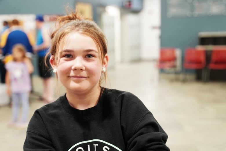 Young girl in black shirt and hair in in bun