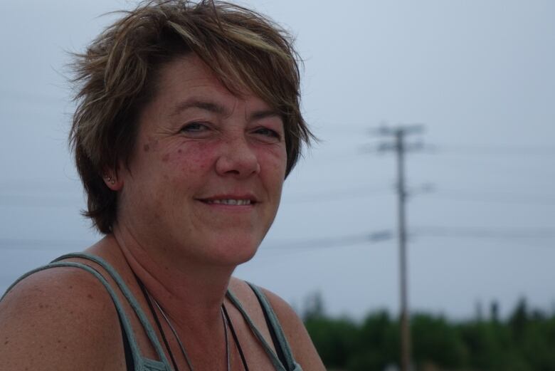 Close up of photo of woman with short hair sitting outdoors