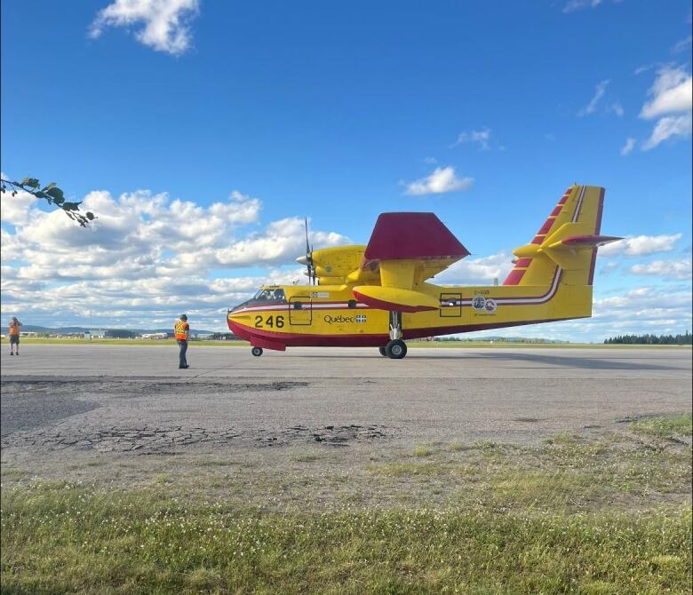 A yellow and red waterbomber sits on a runway.