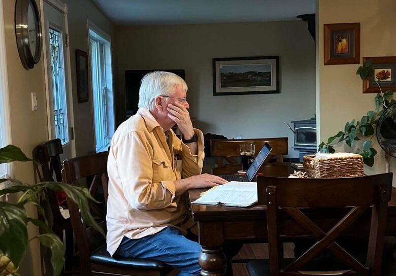 Ken Clark studying economics at a kitchen table.